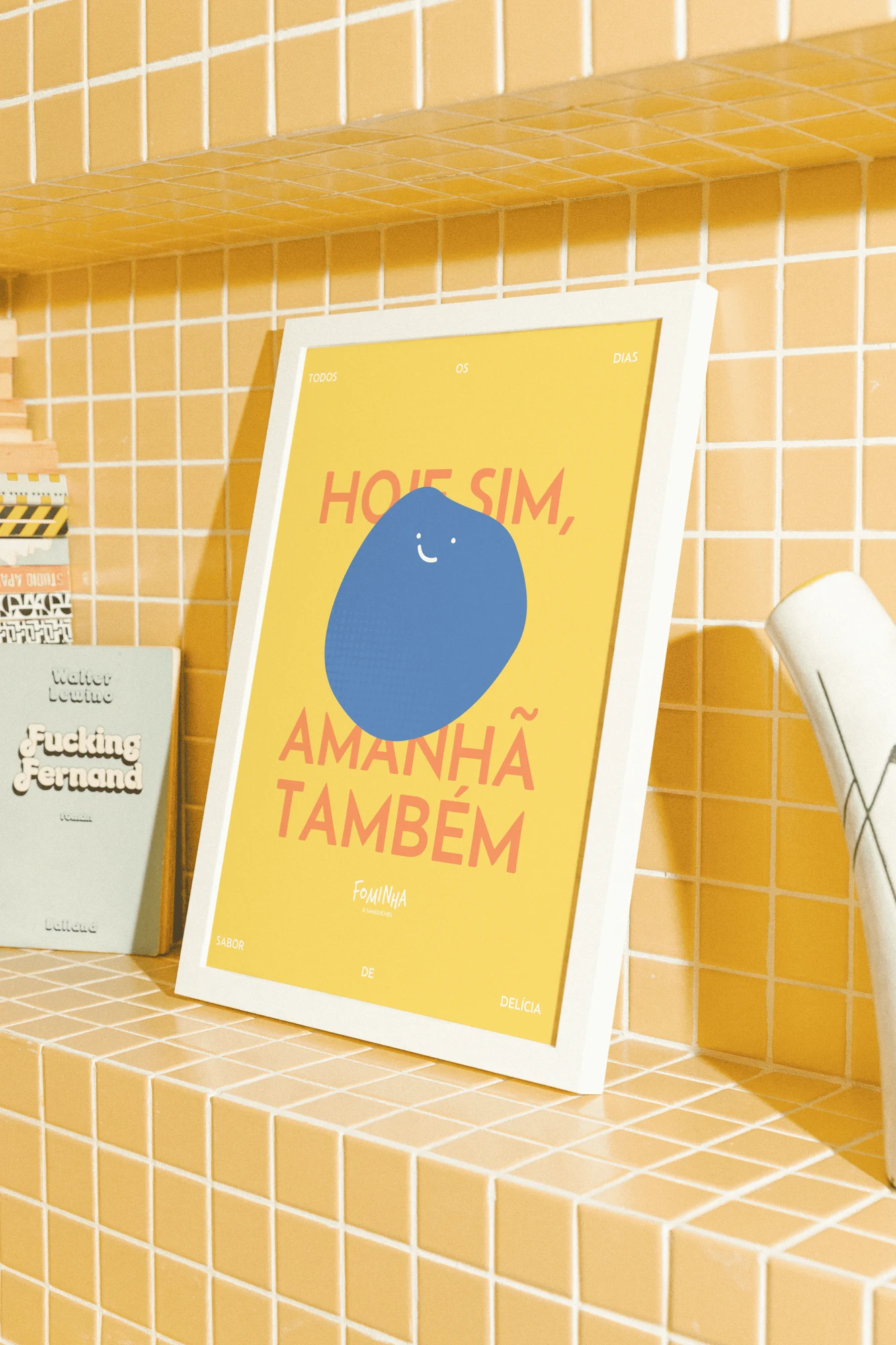 Pôster amarelo Fominha sobre bancada de azulejos